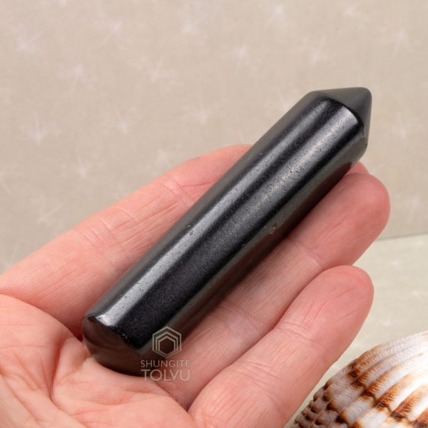rounded end of shungite rod in palm