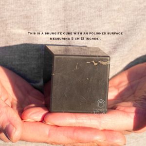 Polished stone cube in hand